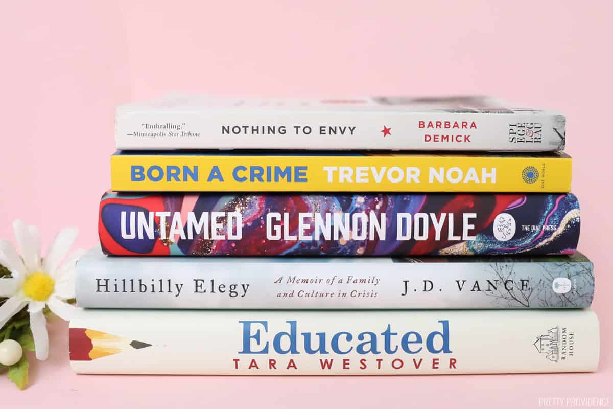 Stack of non-fiction books on a pink background, book club recommendations