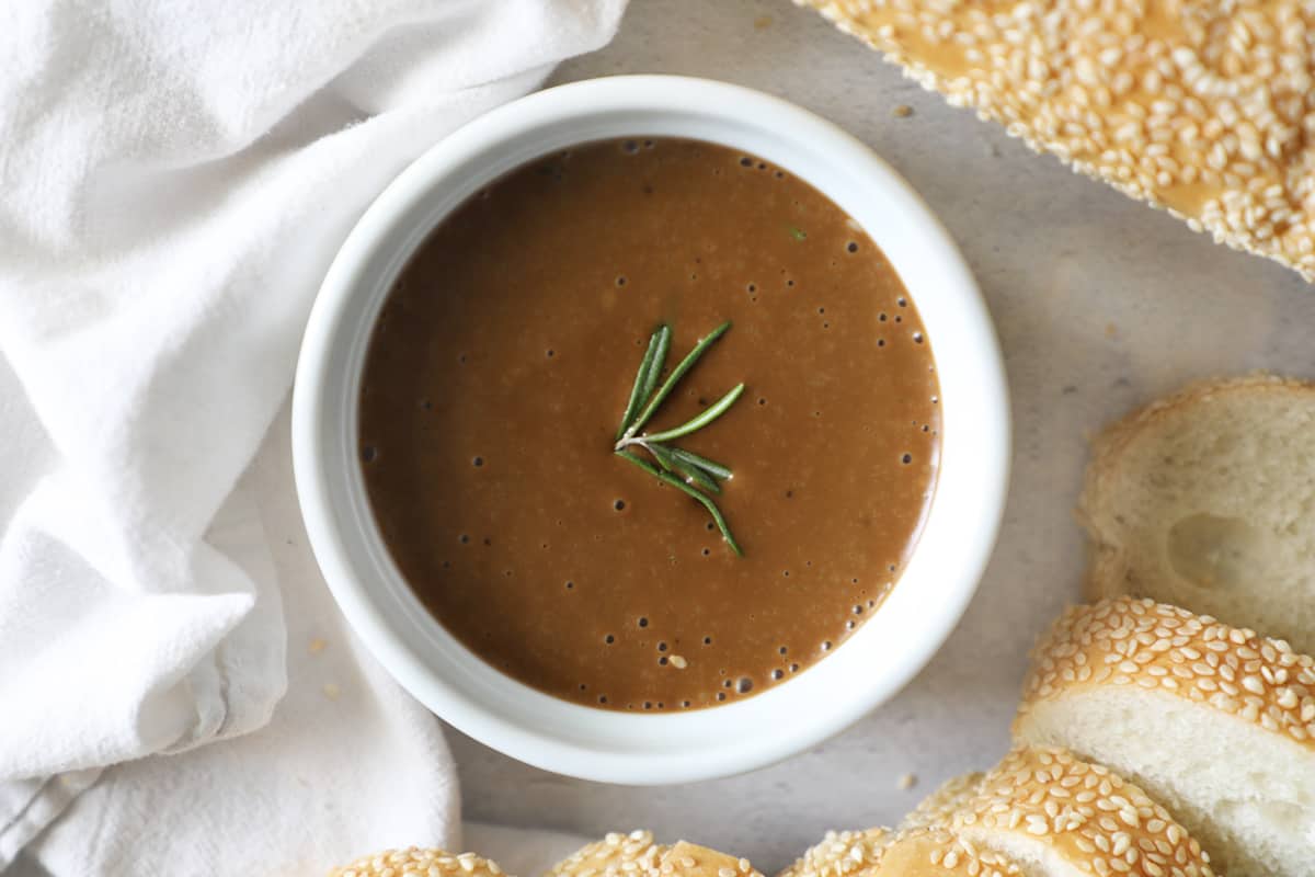 bread dip in a white bowl with rosemary on top