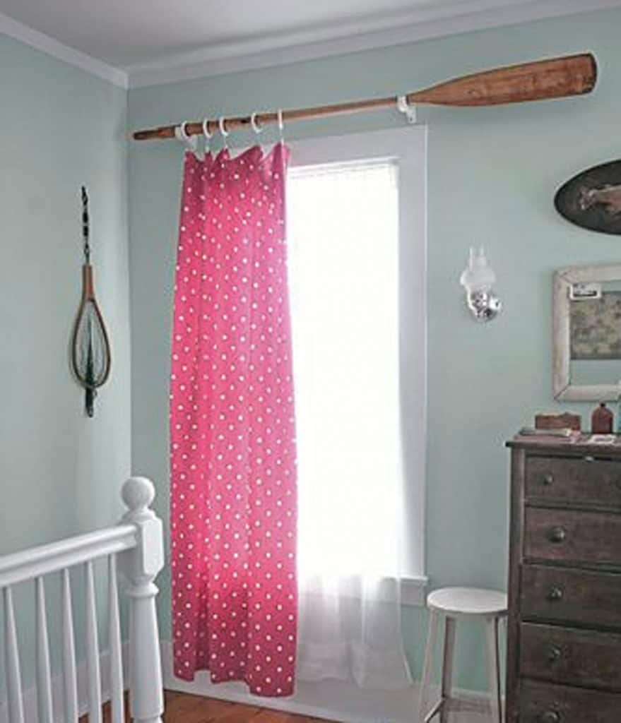 Oar hung on the wall as a curtain rod with red polka dot curtain