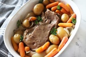 slow cooker pot roast in a white dish