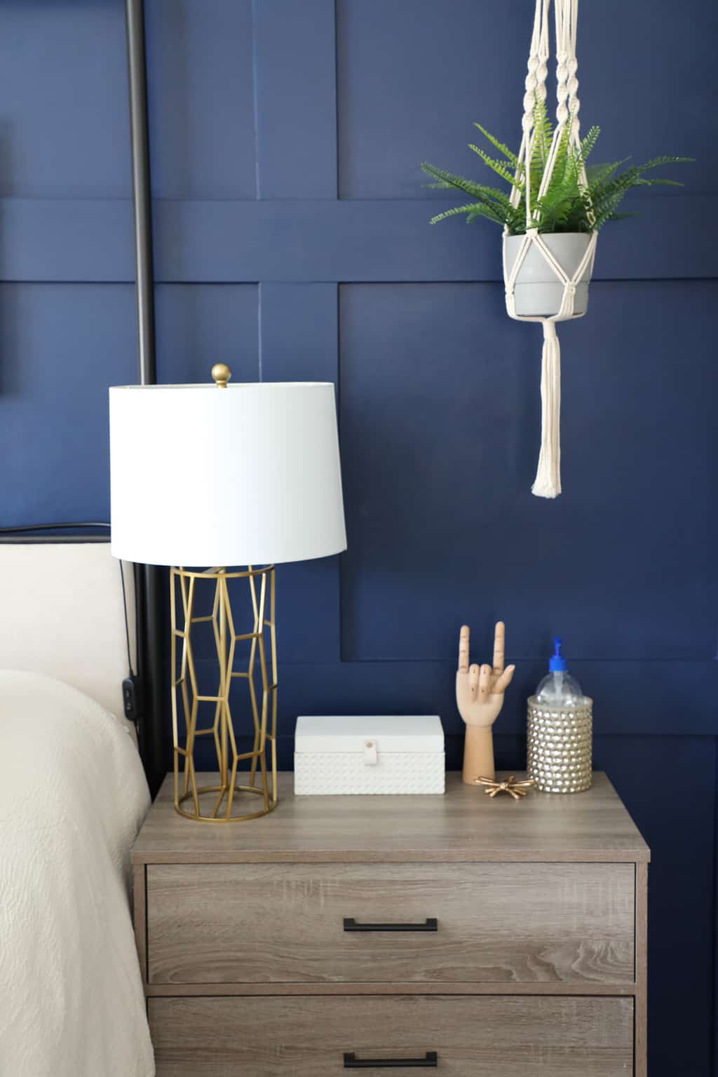 a decorated nightstand in front of the blue accent wall