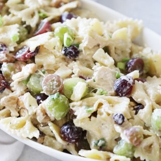 ranch pasta salad in a white bowl with green and purple grapes