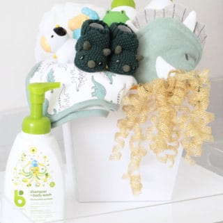 Baby Shower Gift basket with dinosaur towels, green dinosaur slippers, bath toys, baby shampoo and lotion