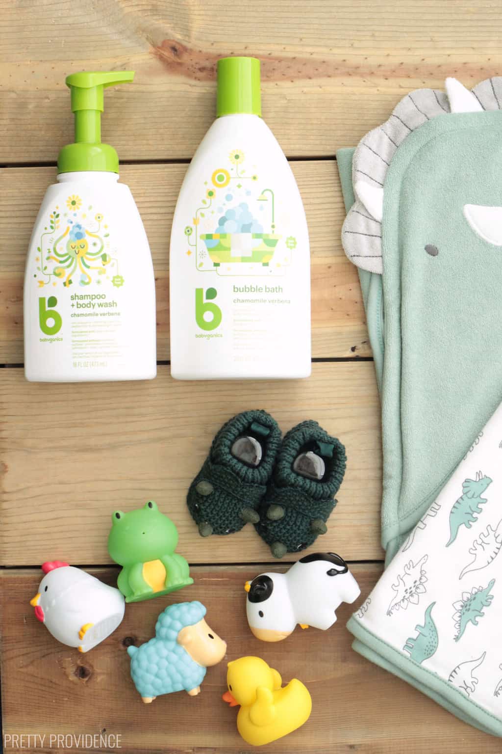 baby shower gift items: dinosaur towels, green dinosaur slippers, bath toys, baby shampoo and lotion