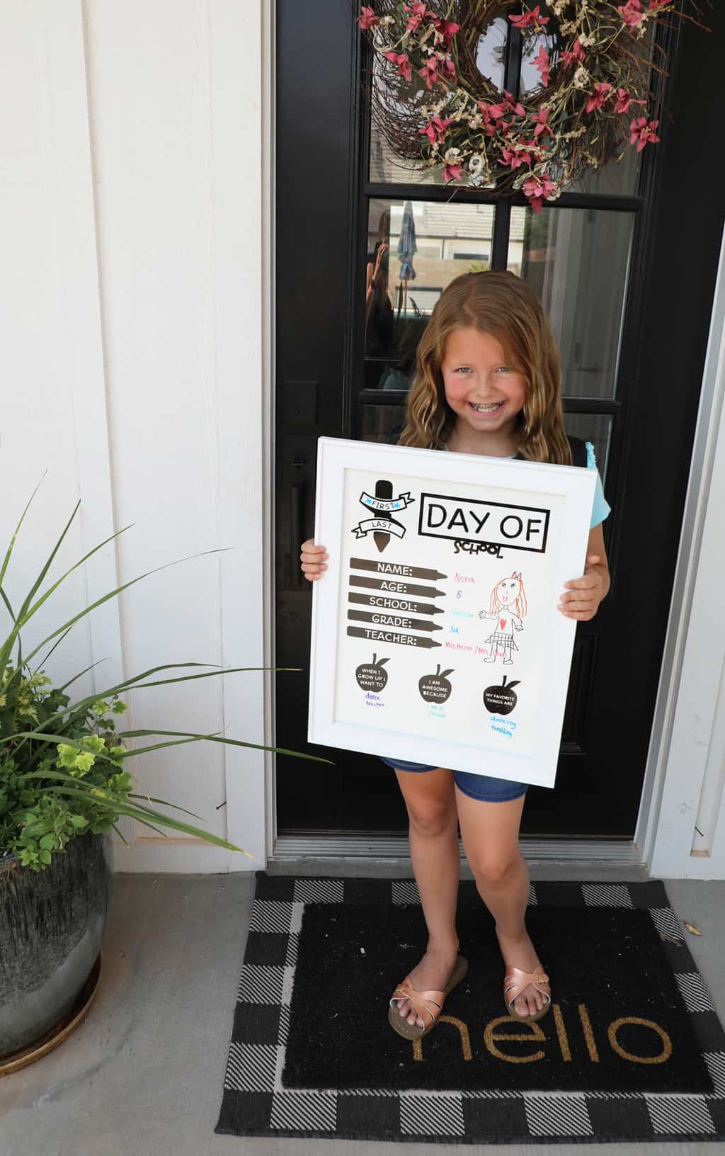 girl holding a back to school board on a front porch
