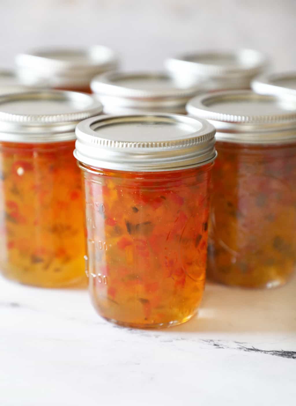 several jars with hot pepper jelly right after being canned