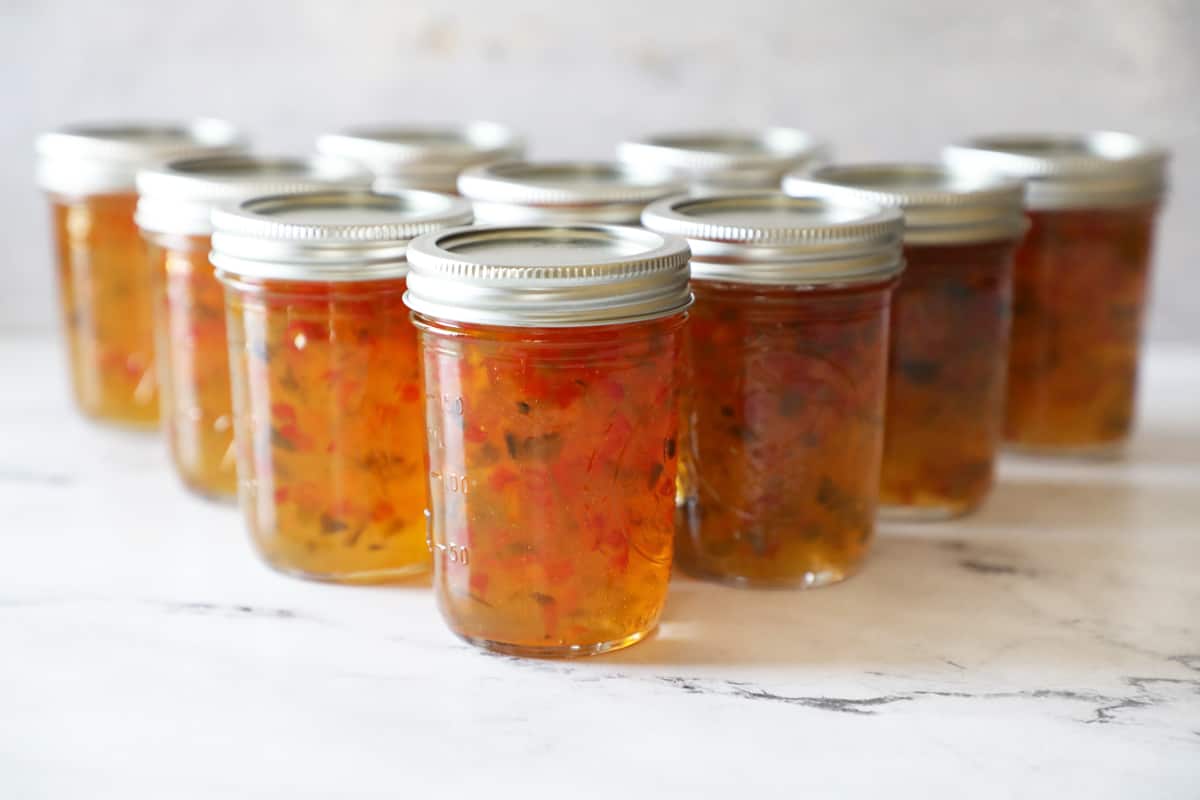 a triangle of jars containing freshly processed pepper jelly