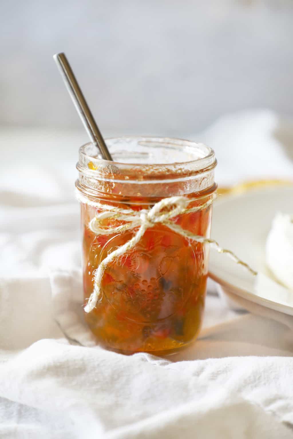 an open jar of pepper jelly with a spoon sticking out