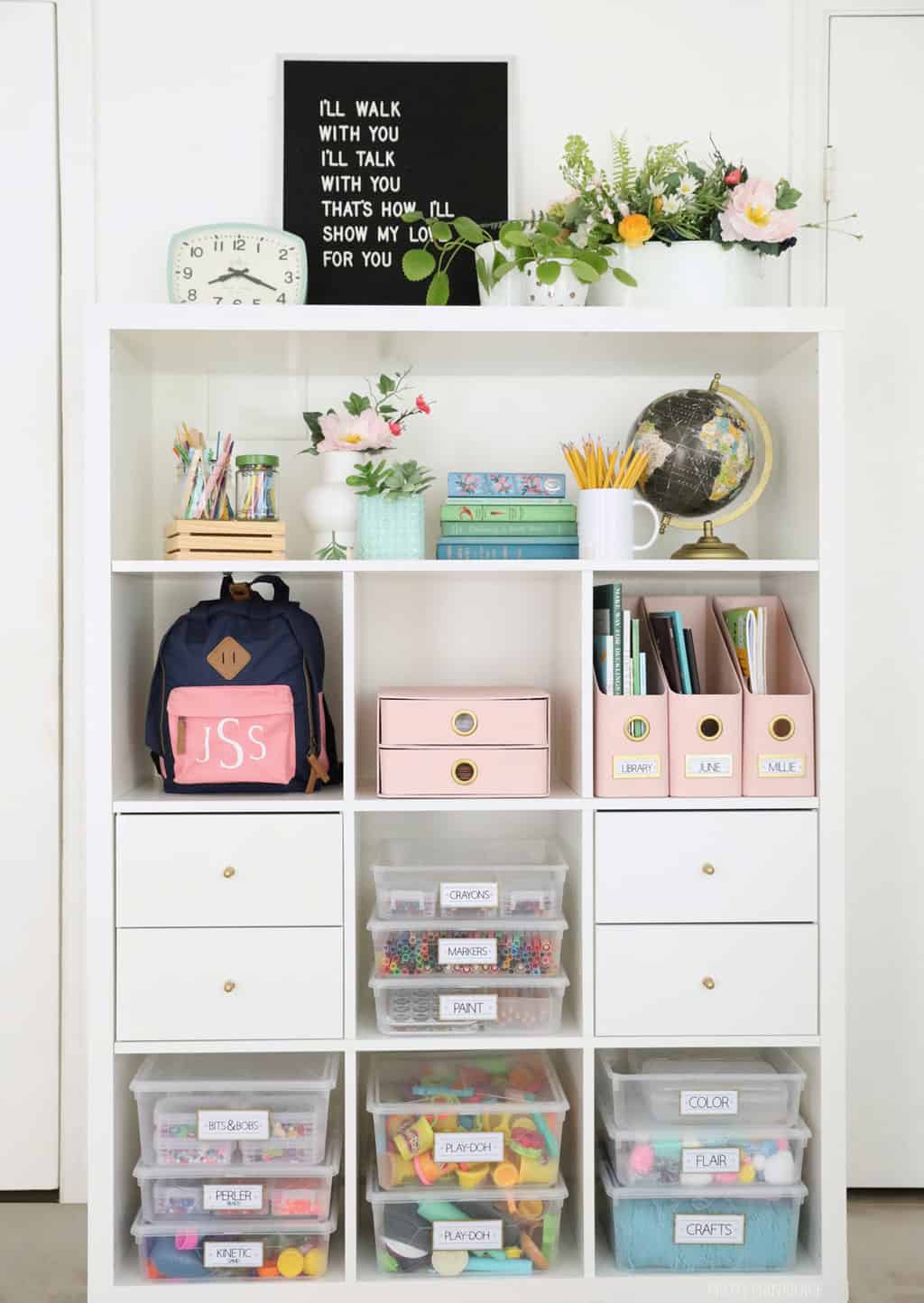 art supplies organized and labeled on a white IKEA kallax shelf