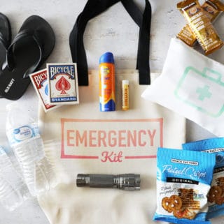 a canvas bag that says emergency kit on it with items surrounding it