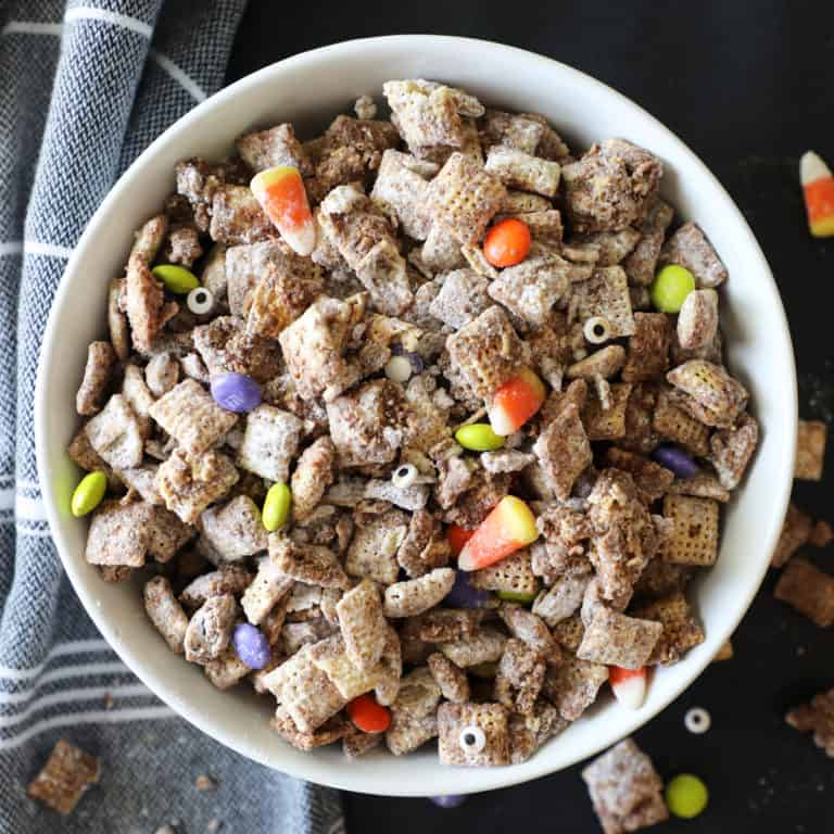 halloween muddy buddies in a white bowl against a black background