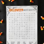 a halloween printable game on a dark background surrounded by candy corn