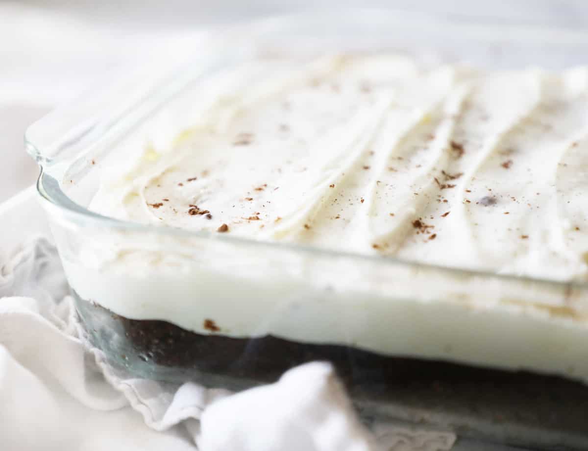 9x13 glass dish with chocolate cake and cream cheese frosting