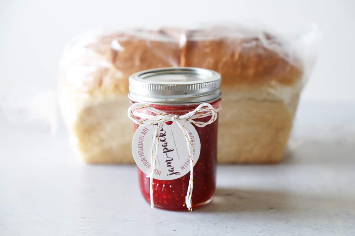 a loaf of fresh bread with homemade jam in front of it
