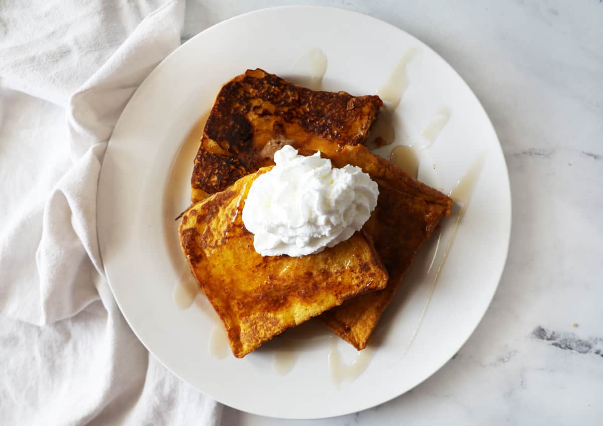 pumpkin French toast topped with syrup and whipped cream