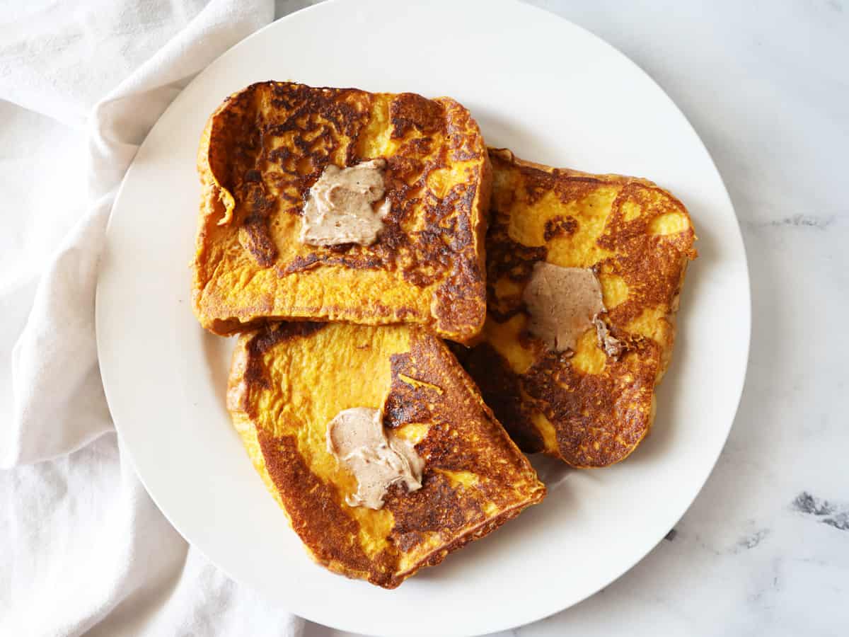 pumpkin spice French toast with pats of brown sugar cinnamon butter on each slice
