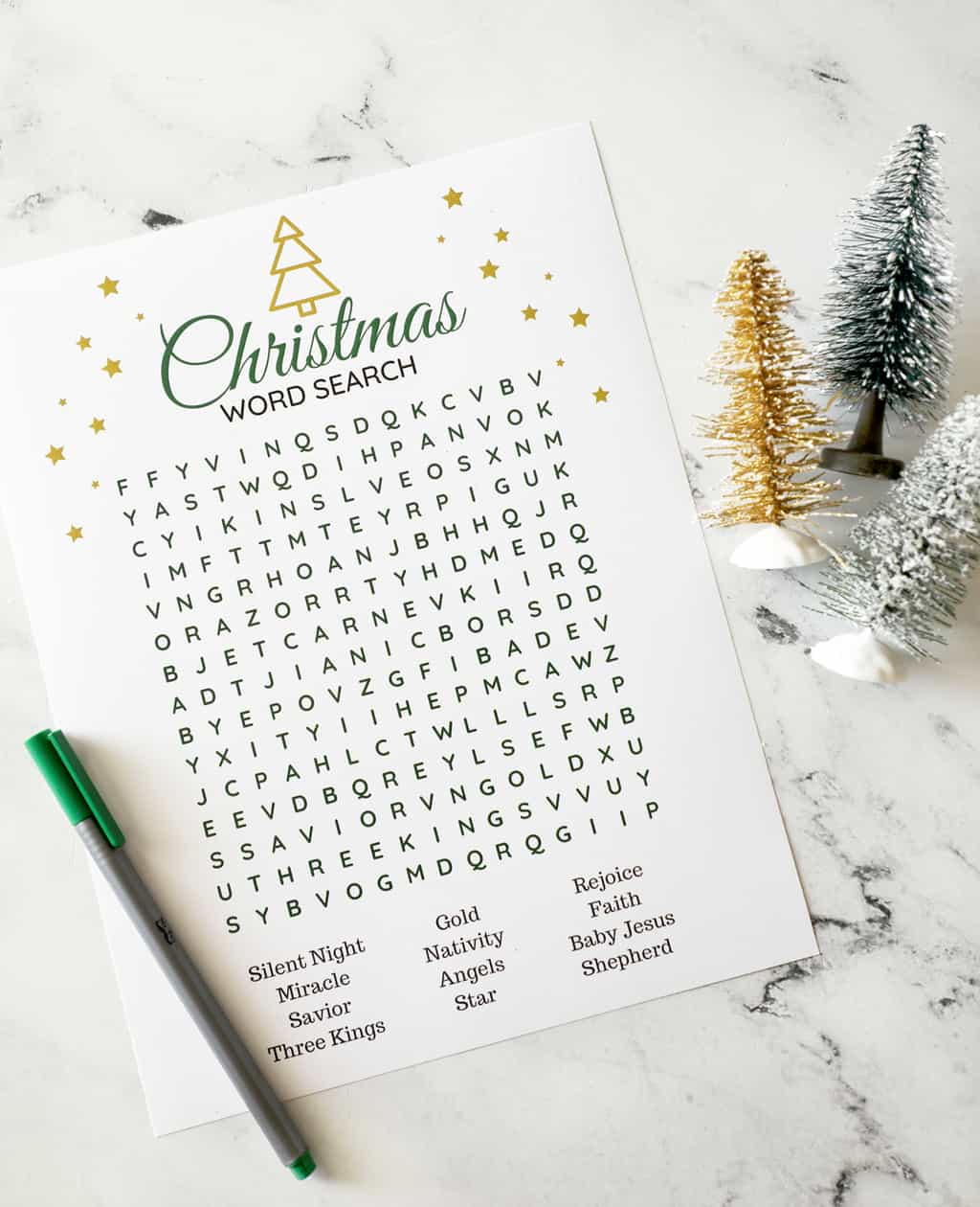 a religious christmas word search in gold and blue next to bottle brush trees