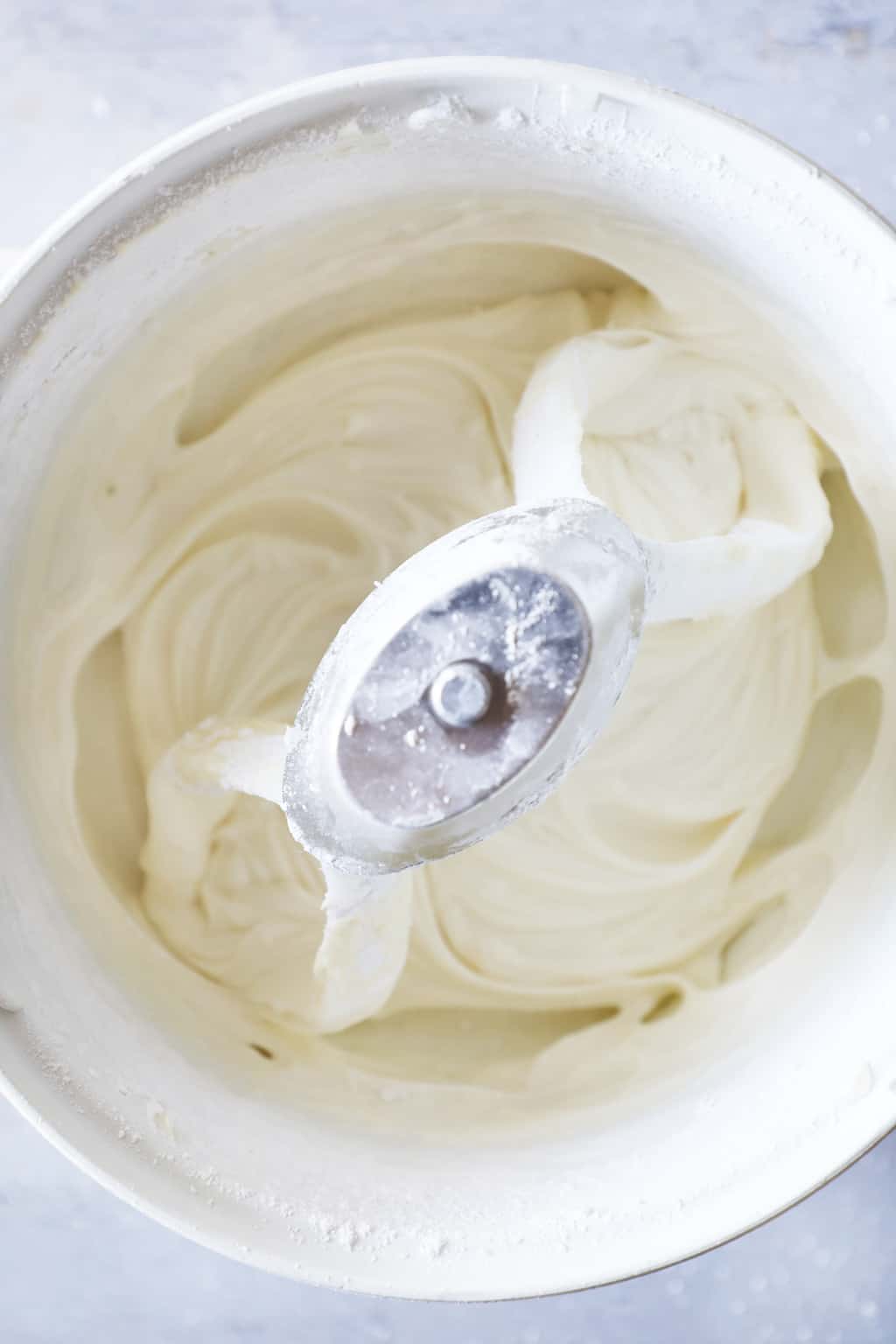 a stand mixer full of cream cheese frosting
