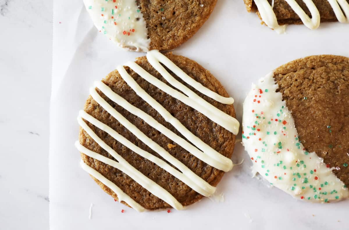 ginger snap cookie with drizzled white chocolate on wax paper