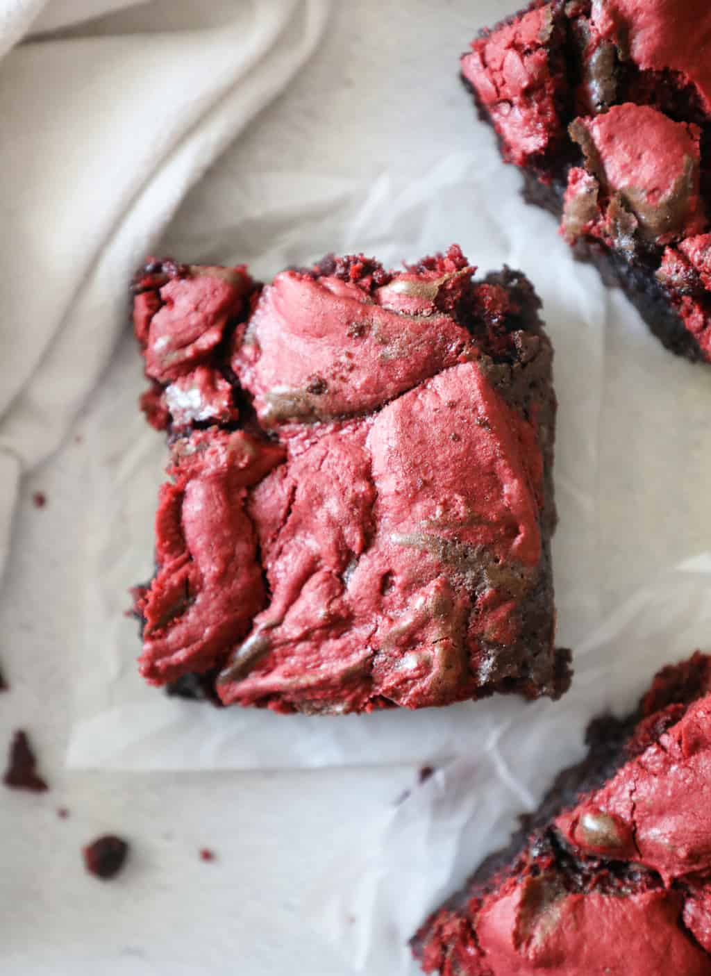 birds eye view of red velvet brownies next to a white tea towel