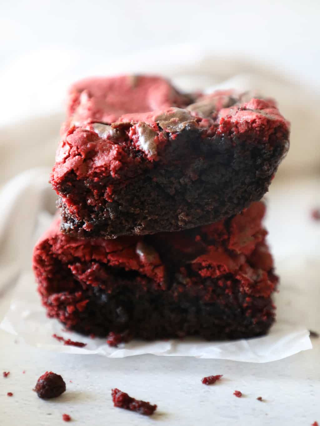 two stacked red velvet brownies against a white backdrop