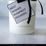 a white candle with a black ribbon and a white and black schitt's Creek inspired gift tag