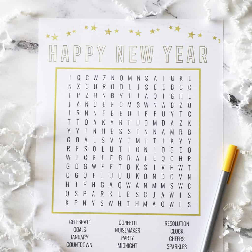 New Years eve word search surrounded by white crinkly paper and a gold pen