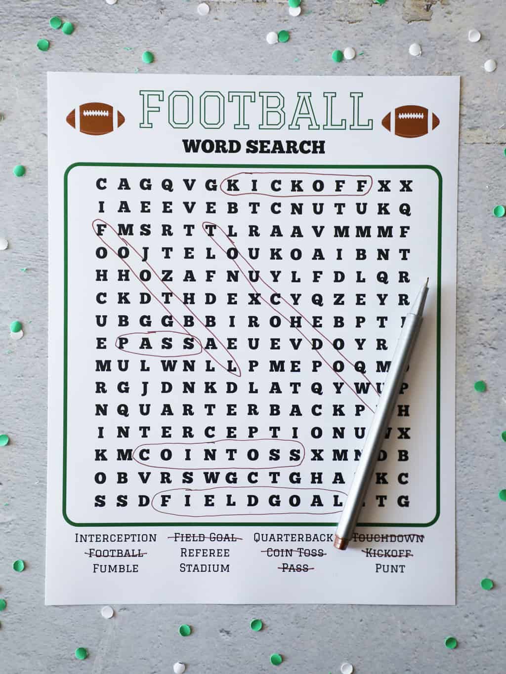 football word search with a pen on top surrounded by green and white confetti