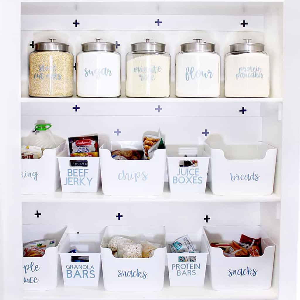 organized pantry shelves with white bins all labeled