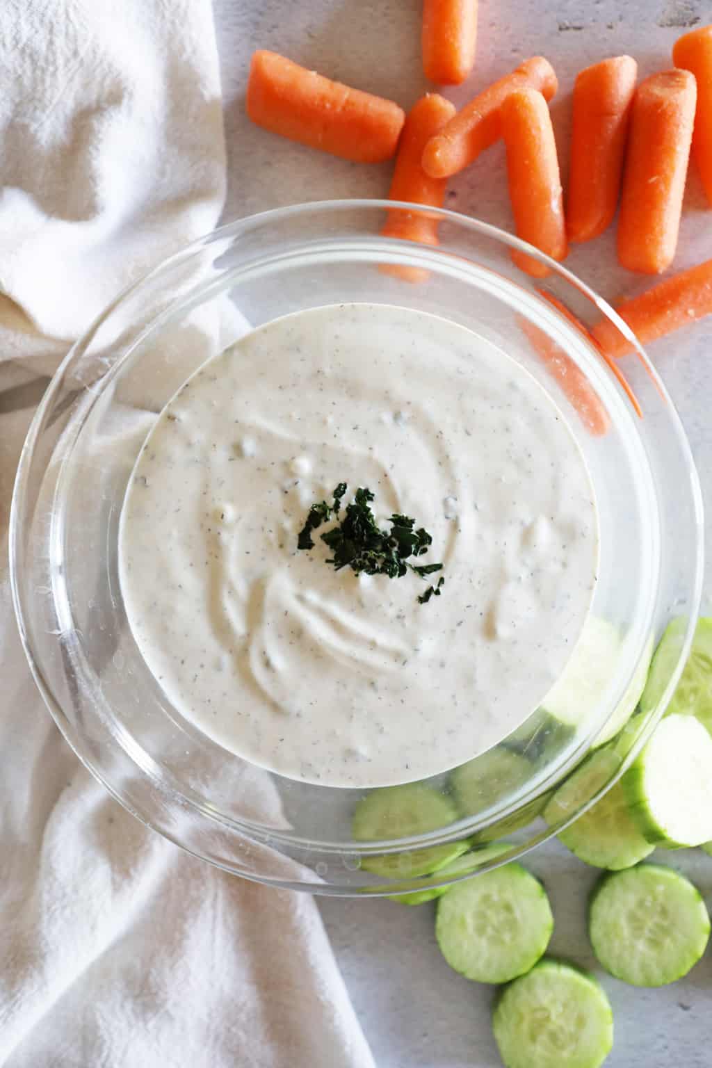 birds eye view of homemade buttermilk ranch dressing with carrots and cucumbers