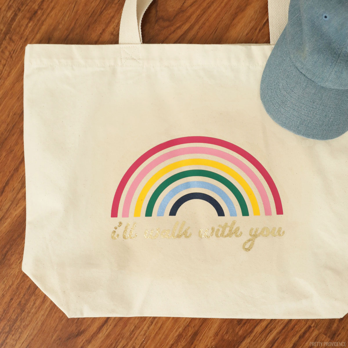 Canvas tote bag with a rainbow on it and the words 'i'll walk with you' under the rainbow