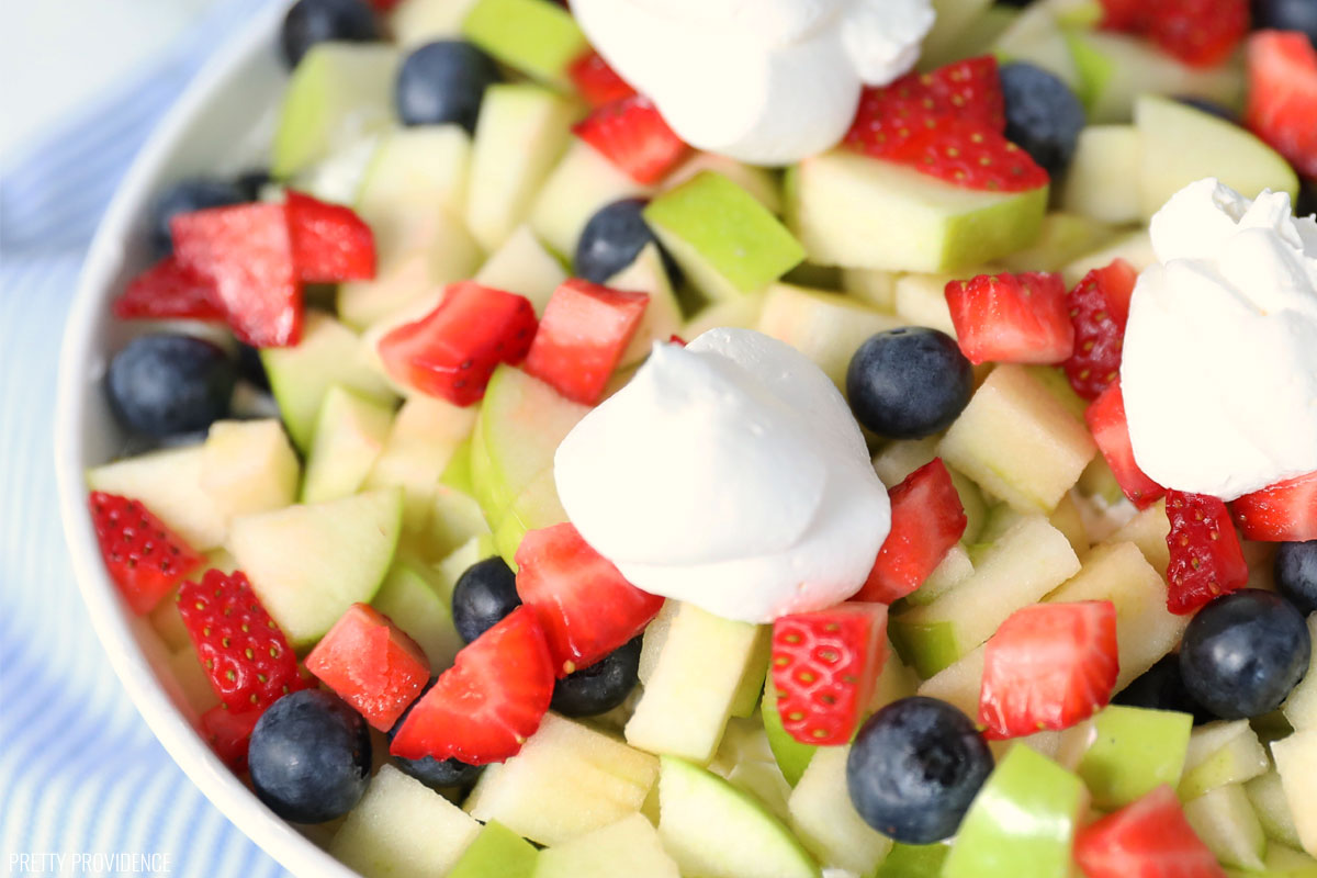 Fruit salad with cool whip made of green apples, strawberries and blueberries