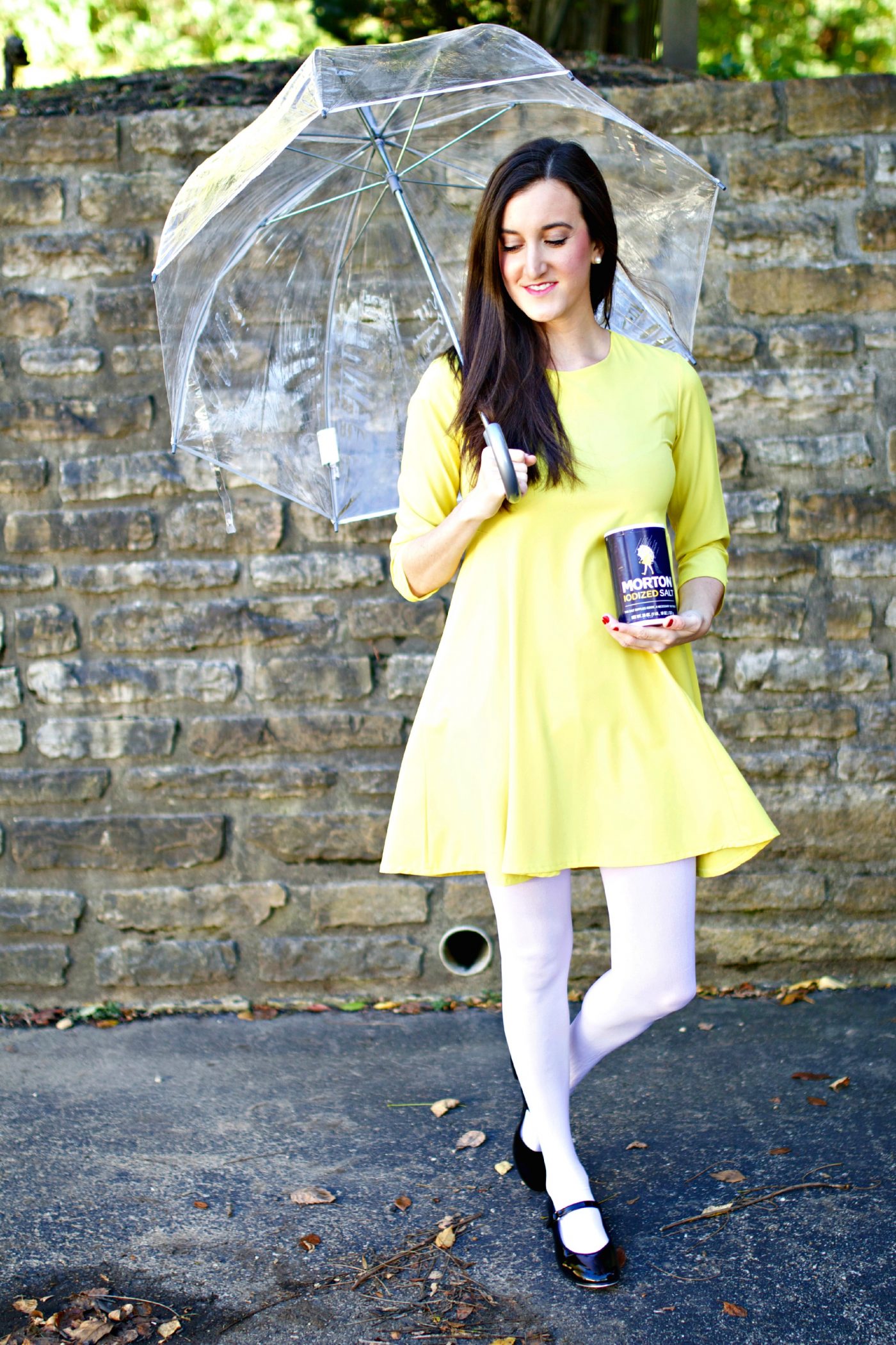 Woman wearing a yellow dress and holding an umbrella with a Morton salt container.