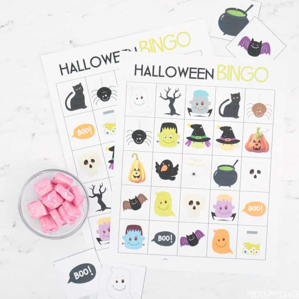 Two Halloween Bingo cards next to a small clear cup of pink starbursts