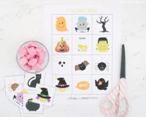 Halloween Bingo calling cards next to pink scissors and treats.