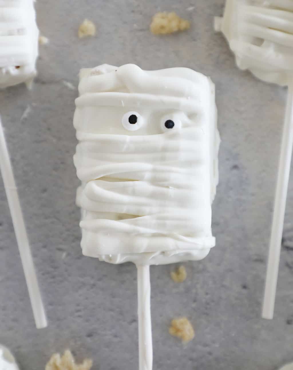 White chocolate covered Rice Krispie treat decorated to look like a mummy. 