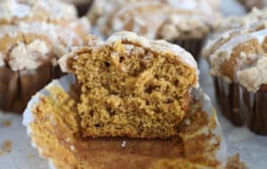 A pumpkin muffin with streusel topping cut in half to reveal the inside.