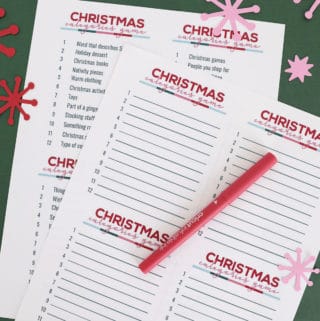 print Christmas scattergories lists with a red pen on a green surface.