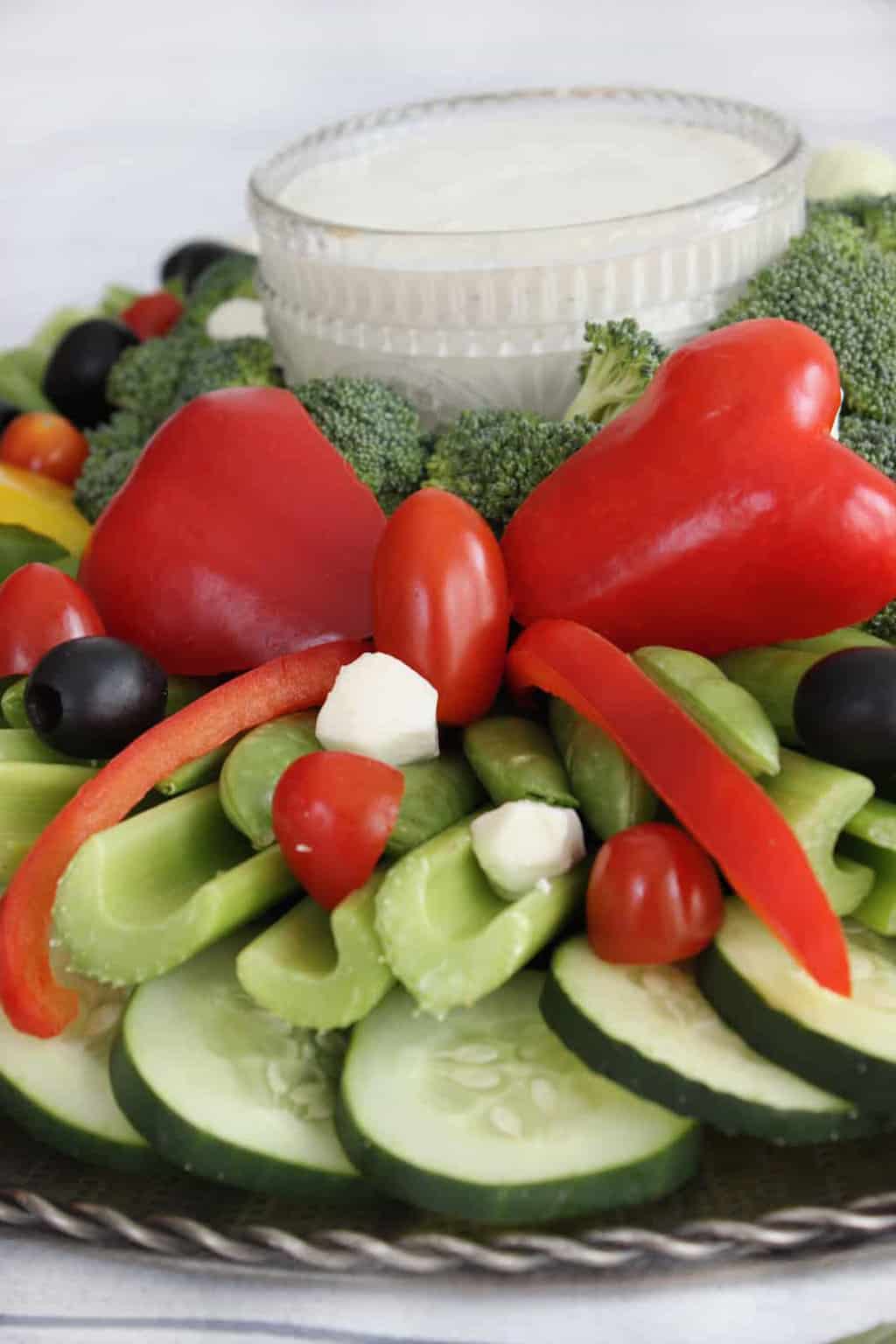 Close up shot of a bow made from a red pepper on a Christmas veggie tray. 