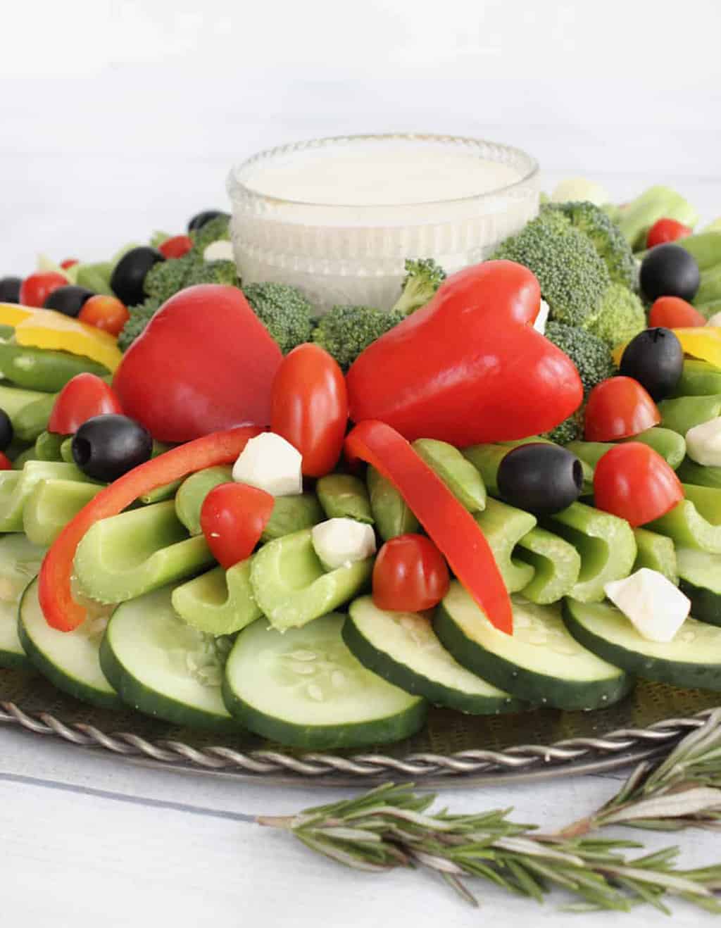 A side view of a veggie tray for Christmas showing a red bow made from a red pepper.