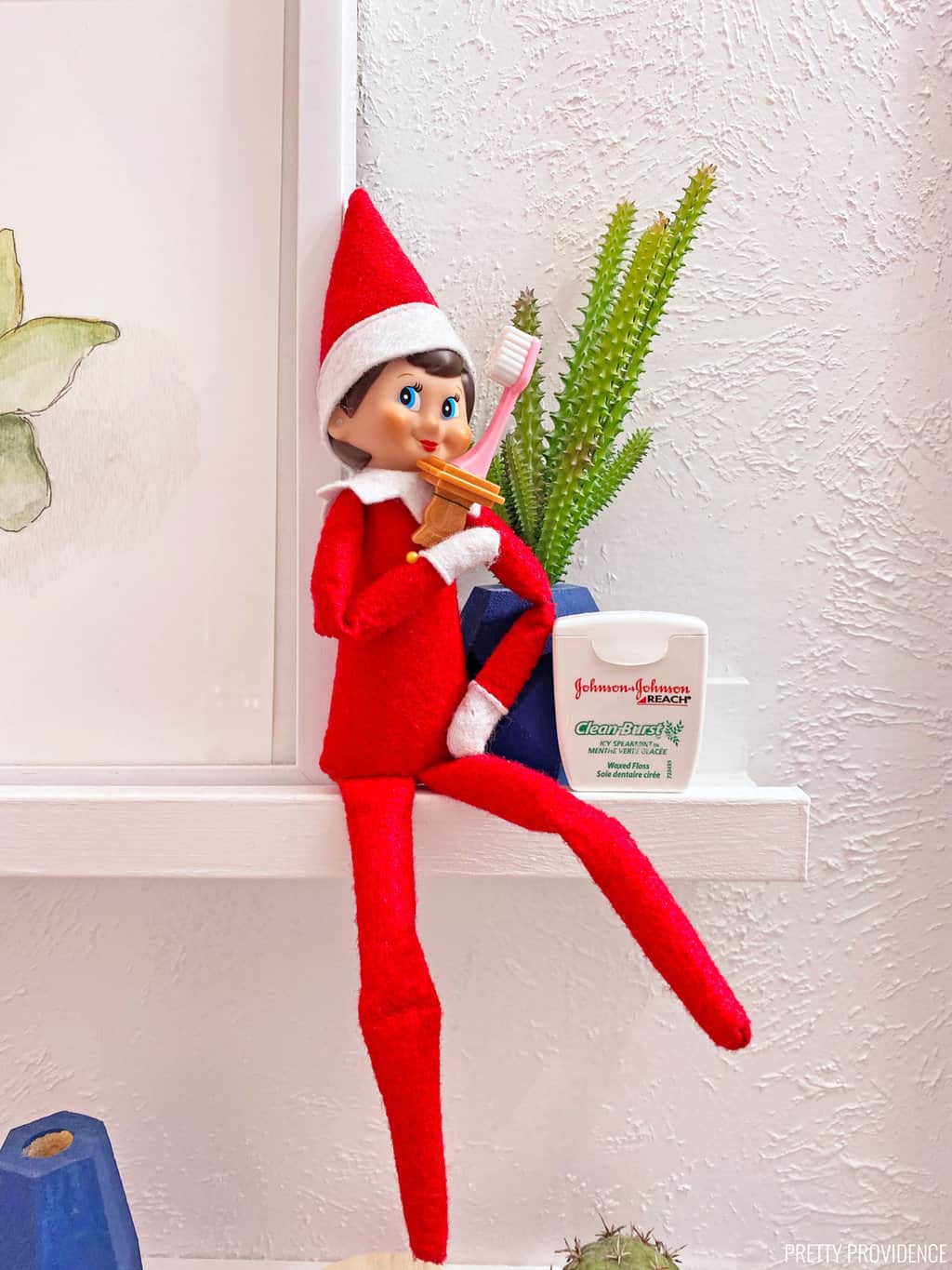 Elf on the Shelf with a toothbrush and floss.