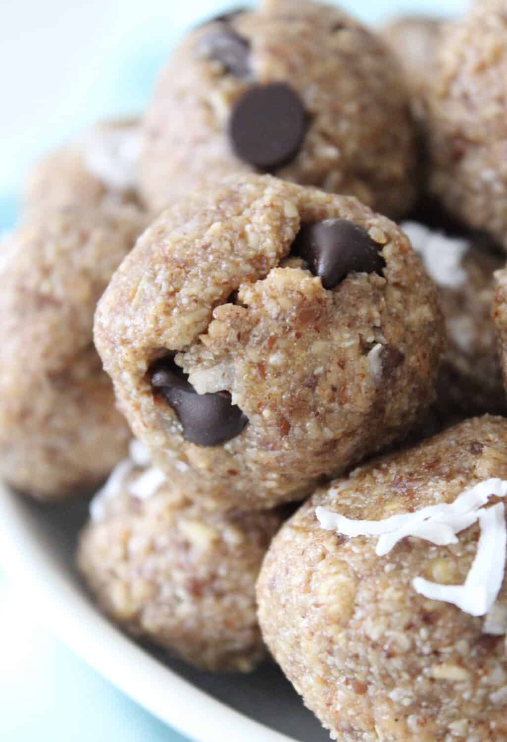 Close up side view of a protein ball with chocolate chips and coconut.