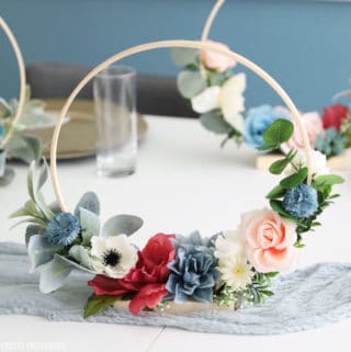 DIY Wedding centerpiece with hoop and faux florals in dusty blue, pink, ivory, and raspberry..
