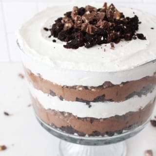 Close up view of a layered chocolate trifle with brownies, symphony bar, whipped cream and chocolate mousse.