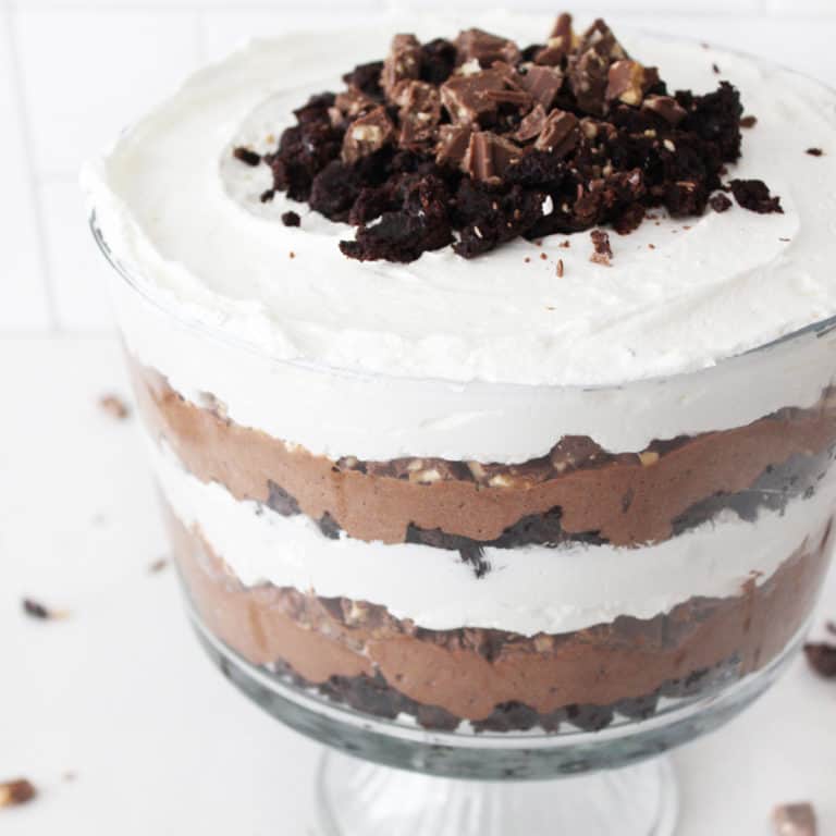 Close up view of a layered chocolate trifle with brownies, symphony bar, whipped cream and chocolate mousse.