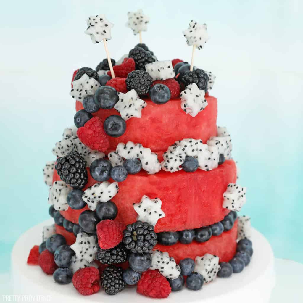 Fresh watermelon cake, two-tiers of watermelon decorated with blueberries, blackberries, raspberries and dragonfruit cut into star shapes.