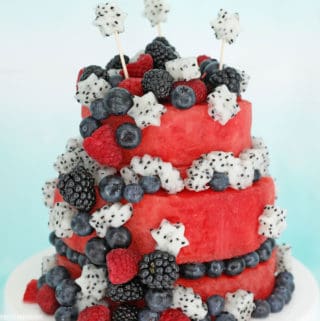 Fresh watermelon cake, two-tiers of watermelon decorated with blueberries, blackberries, raspberries and dragonfruit cut into star shapes.
