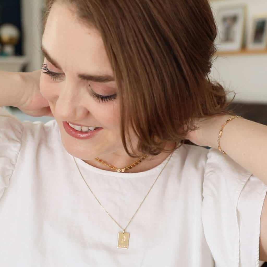 A woman putting on a Made by Mary necklace.