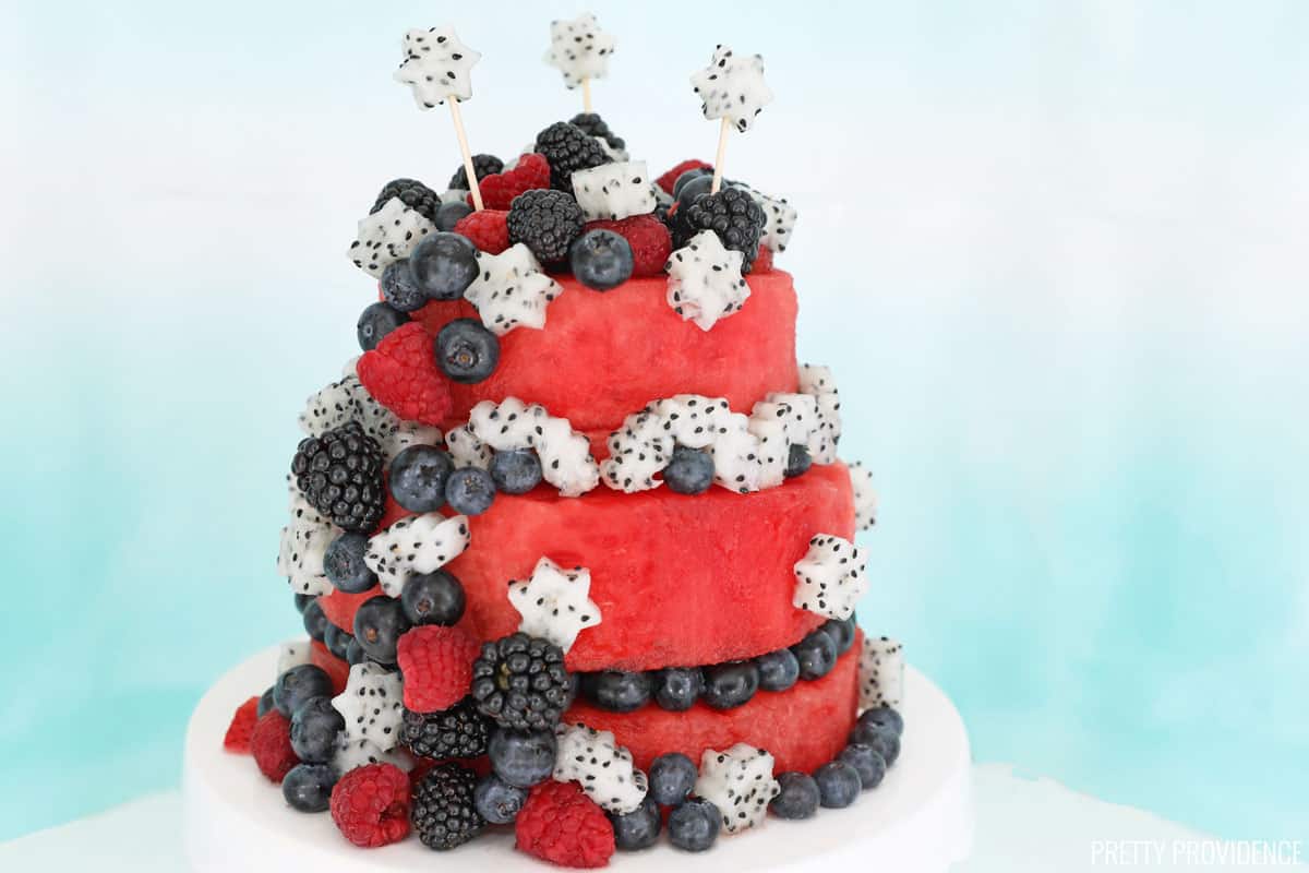 Watermelon cake, two-tiers of watermelon decorated with blueberries, blackberries, raspberries and dragonfruit cut into star shapes.
