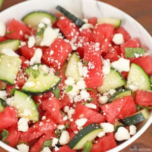 Watermelon feta salad with cucumber and mint in a white bowl.